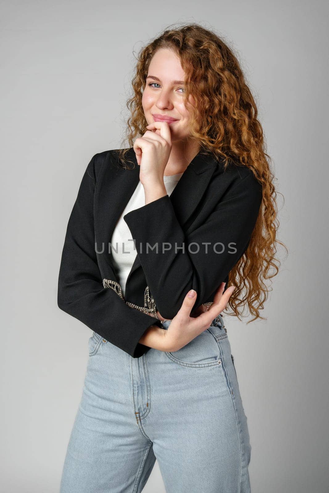 Thoughtful Young Woman Against Grey Background in Studio close up