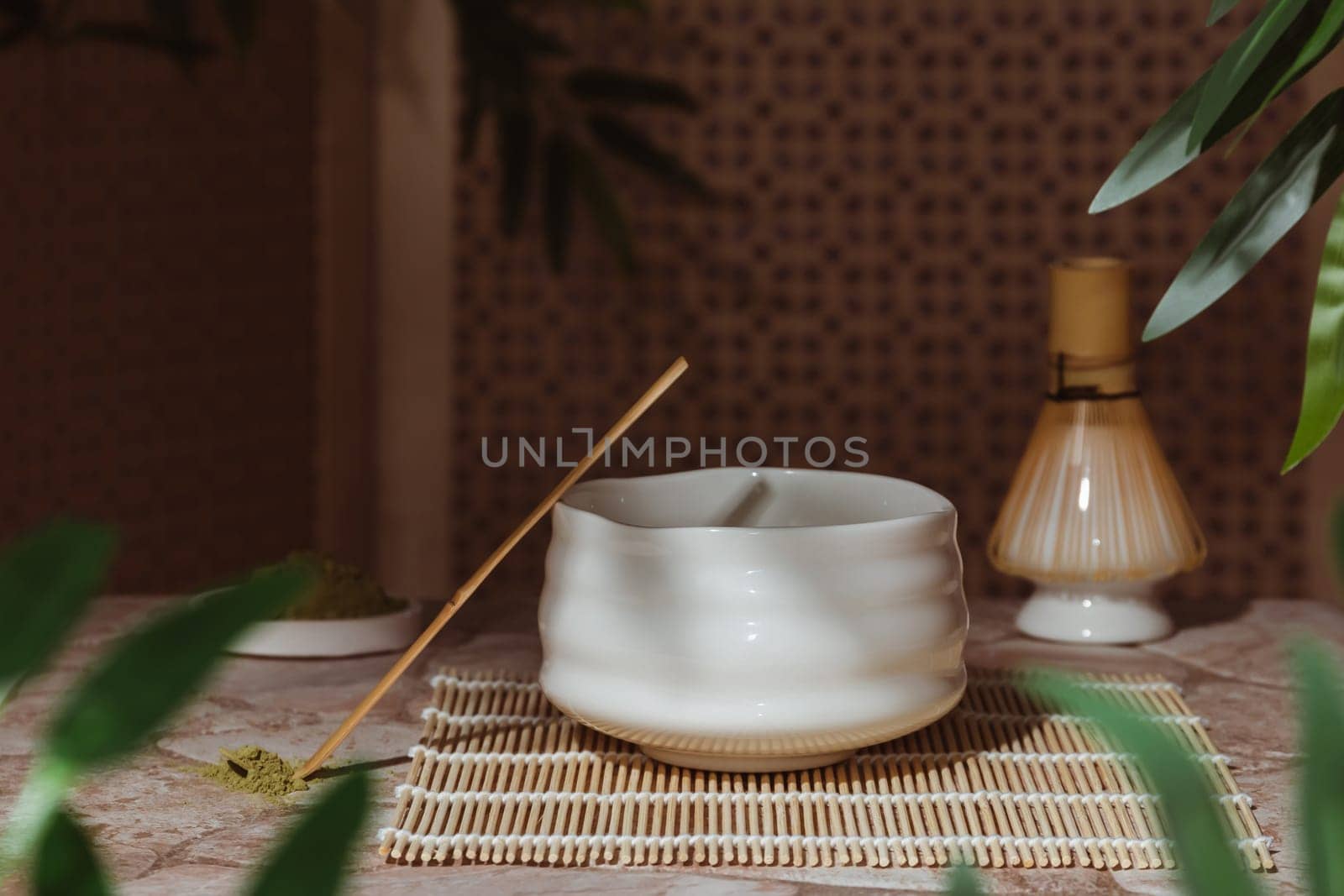 Japanese tea ceremony with a matcha. Tyawan, tyasaku, tyasen on a stone table top among bamboo leaves