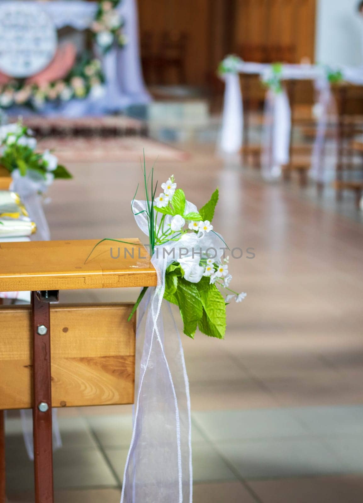 Close up shot of the pews at the Roman catholic church decorated with flowers