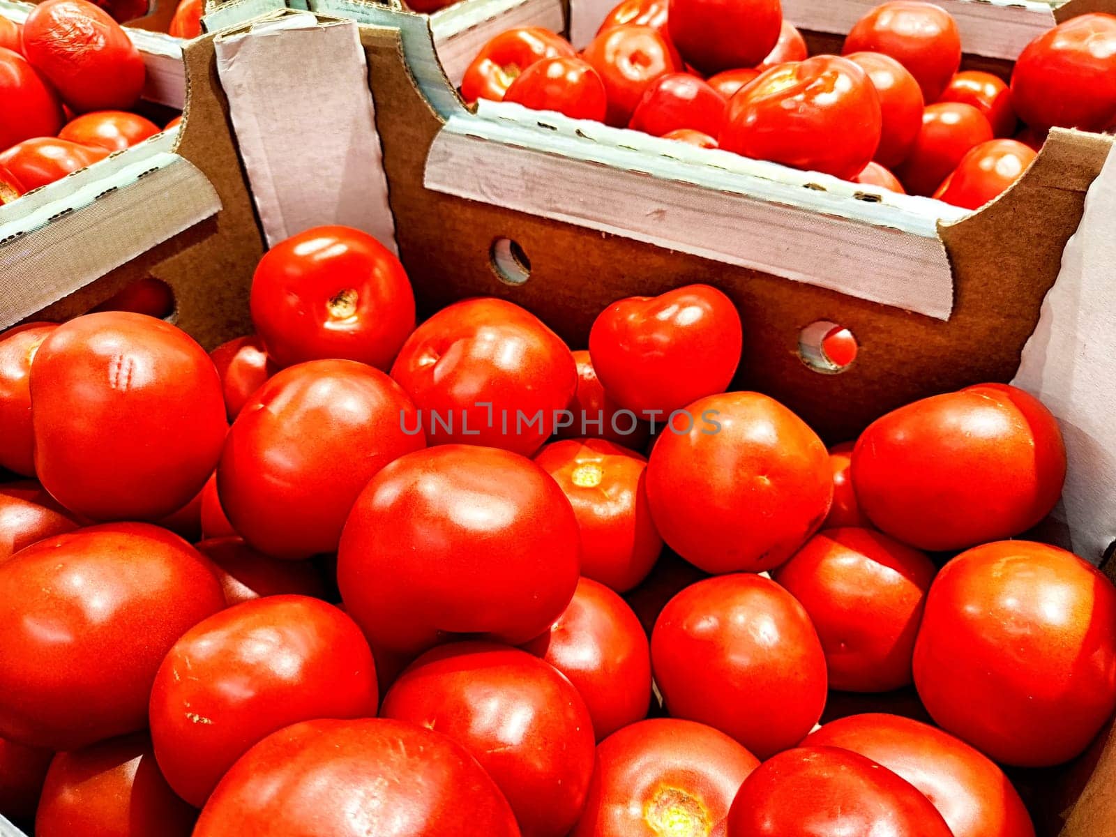 Red ripe tomatoes in cardboard boxes. Fresh Tomatoes Displayed for Sale at a Local Market