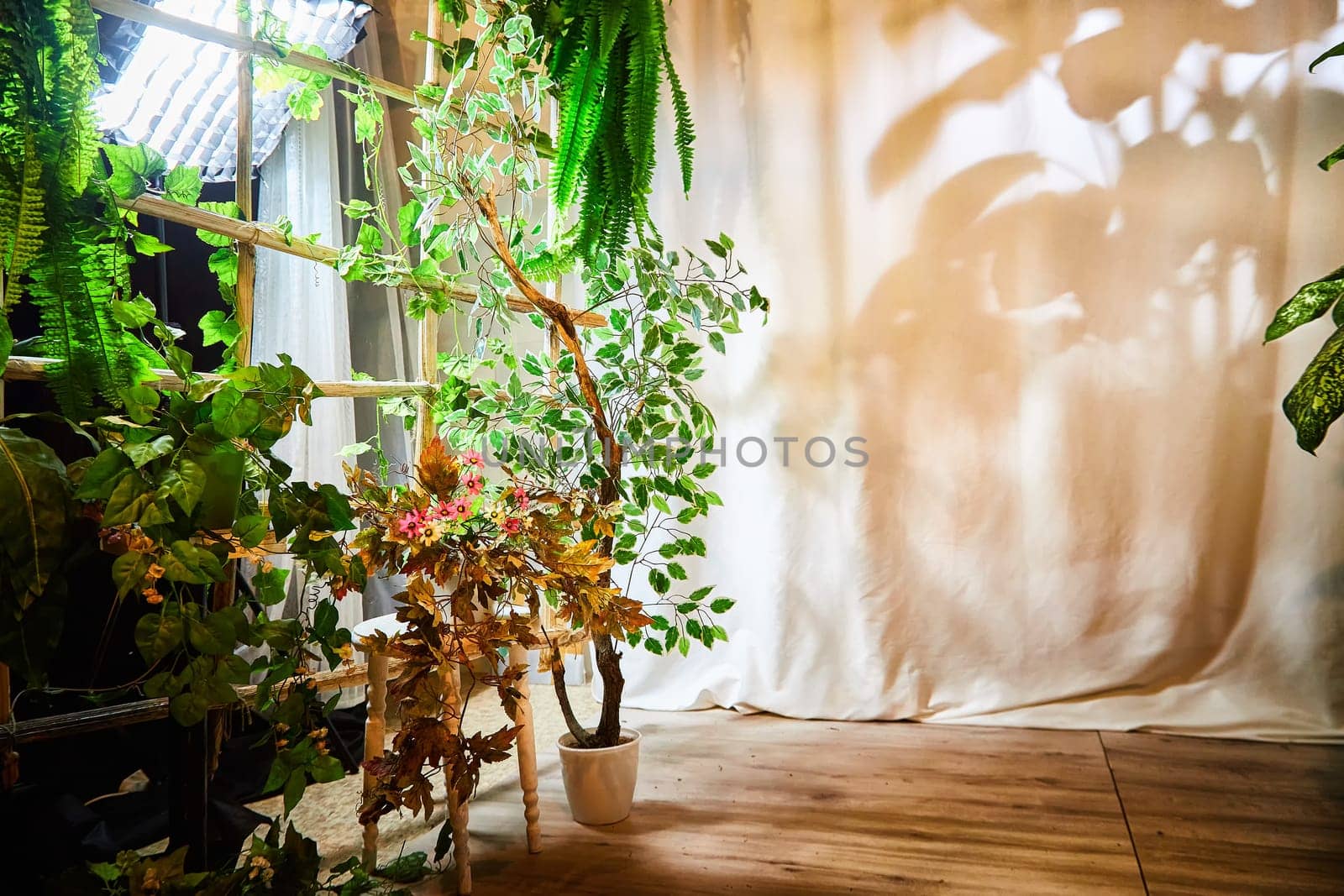 Living room with fabric curtains, home flowers, lighting. Loft style in interior. Background and location for photo shoot