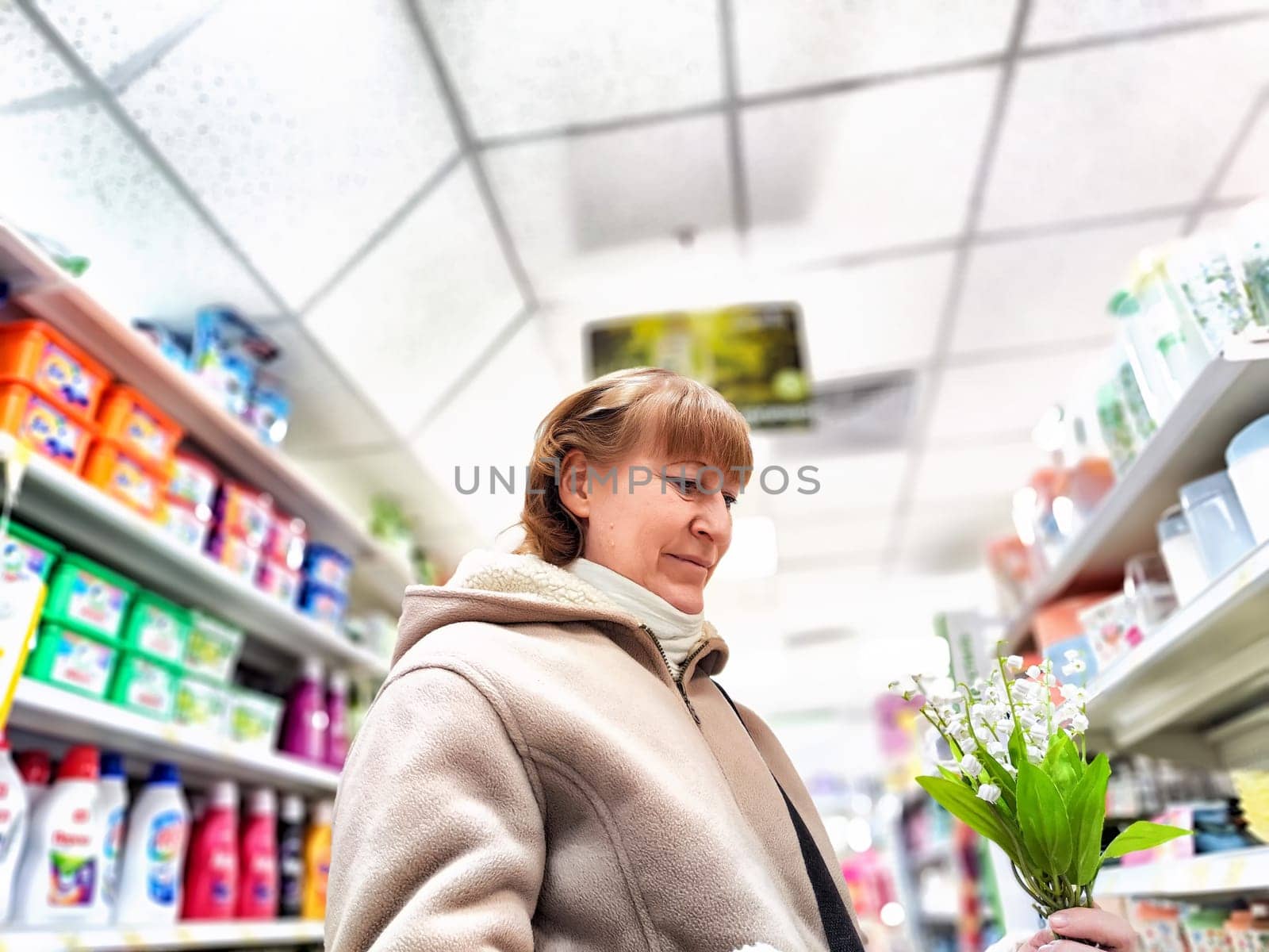 Middle-Aged Woman Shopping for Care Products at a Cosmetics Store. A woman browsing care products in well-stocked cosmetics aisle