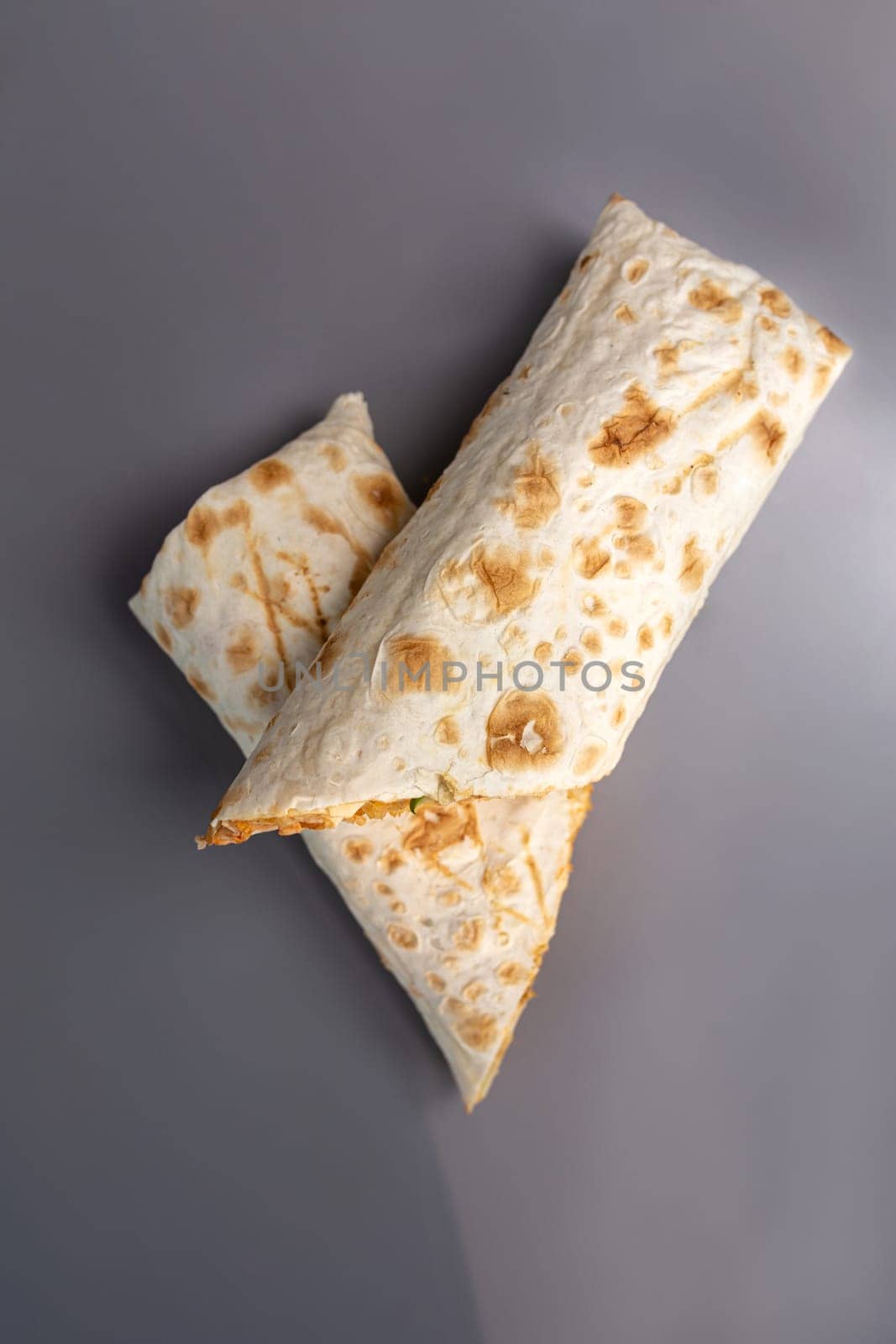 appetizing cut doner in pita bread on a gray background.