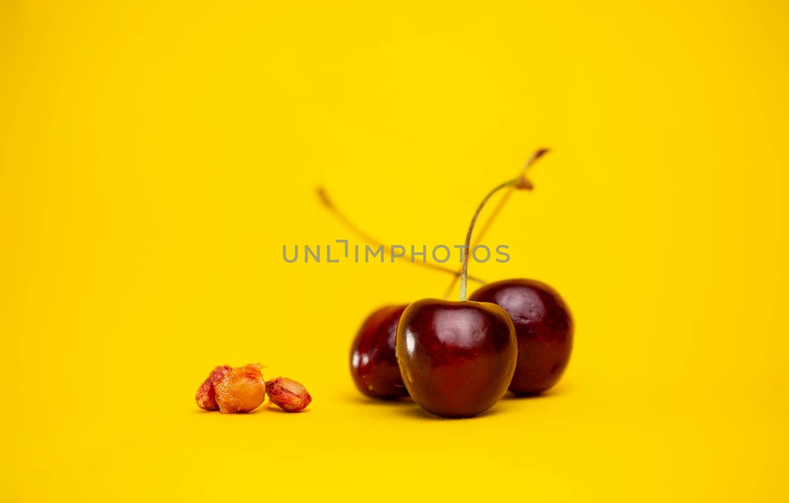 ripe cherries with pits are isolated against the background by Pukhovskiy
