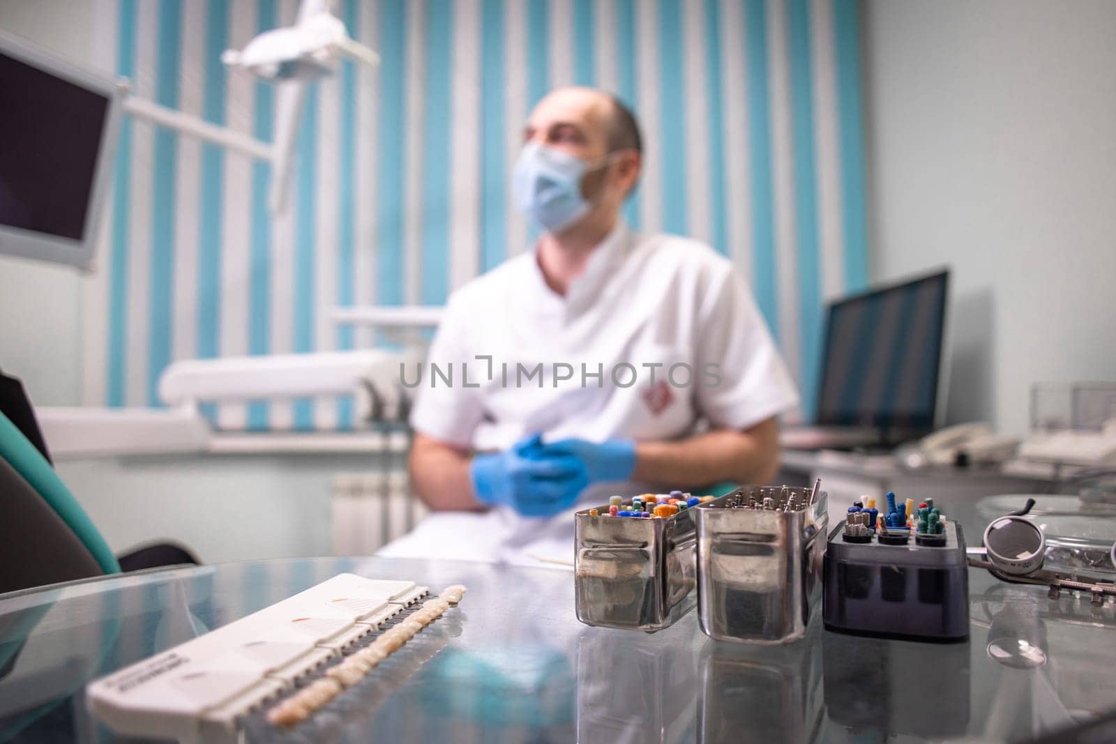 dental tools in the background of the doctor in the office by Pukhovskiy