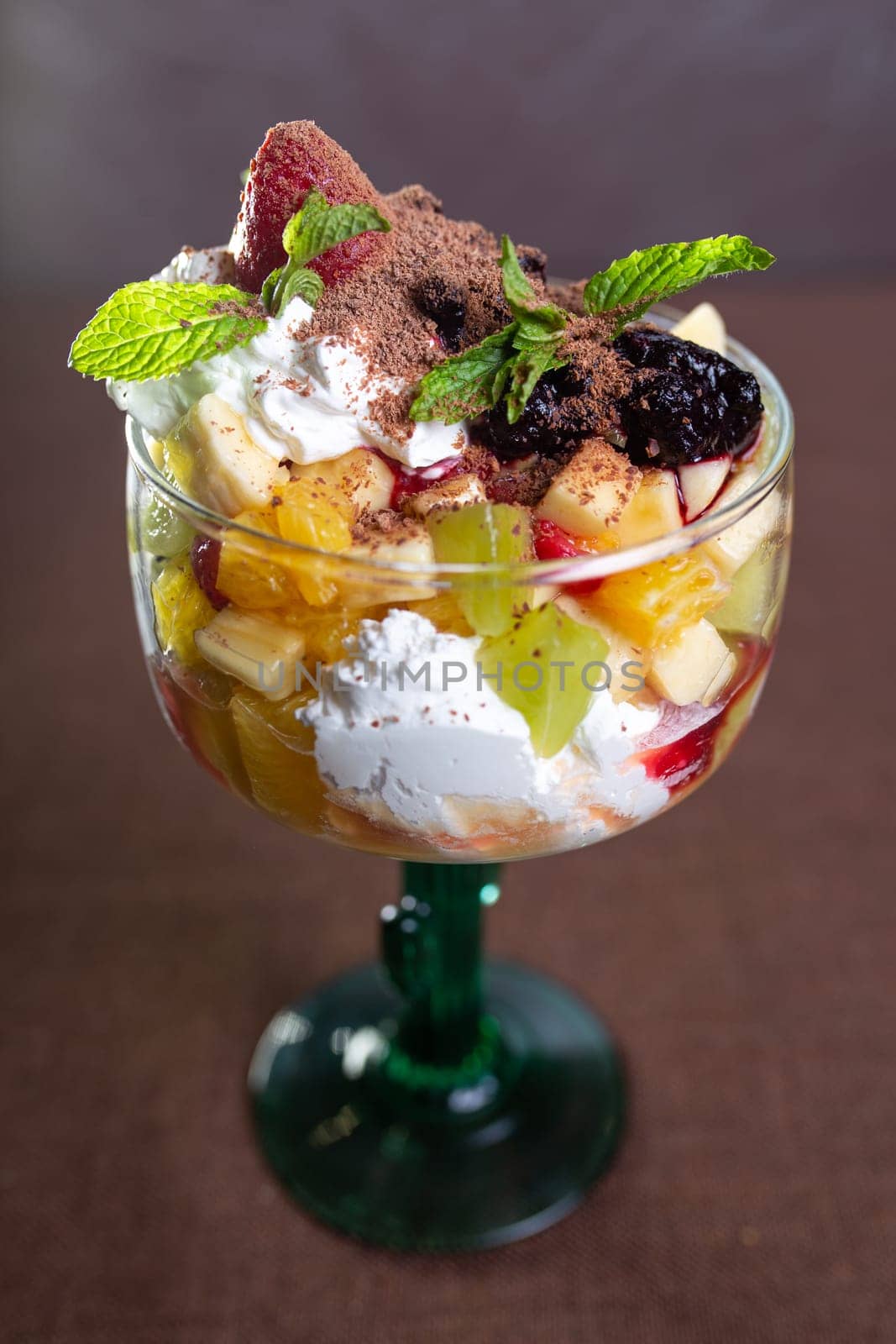 fruit dessert with ice cream in a glass glass.