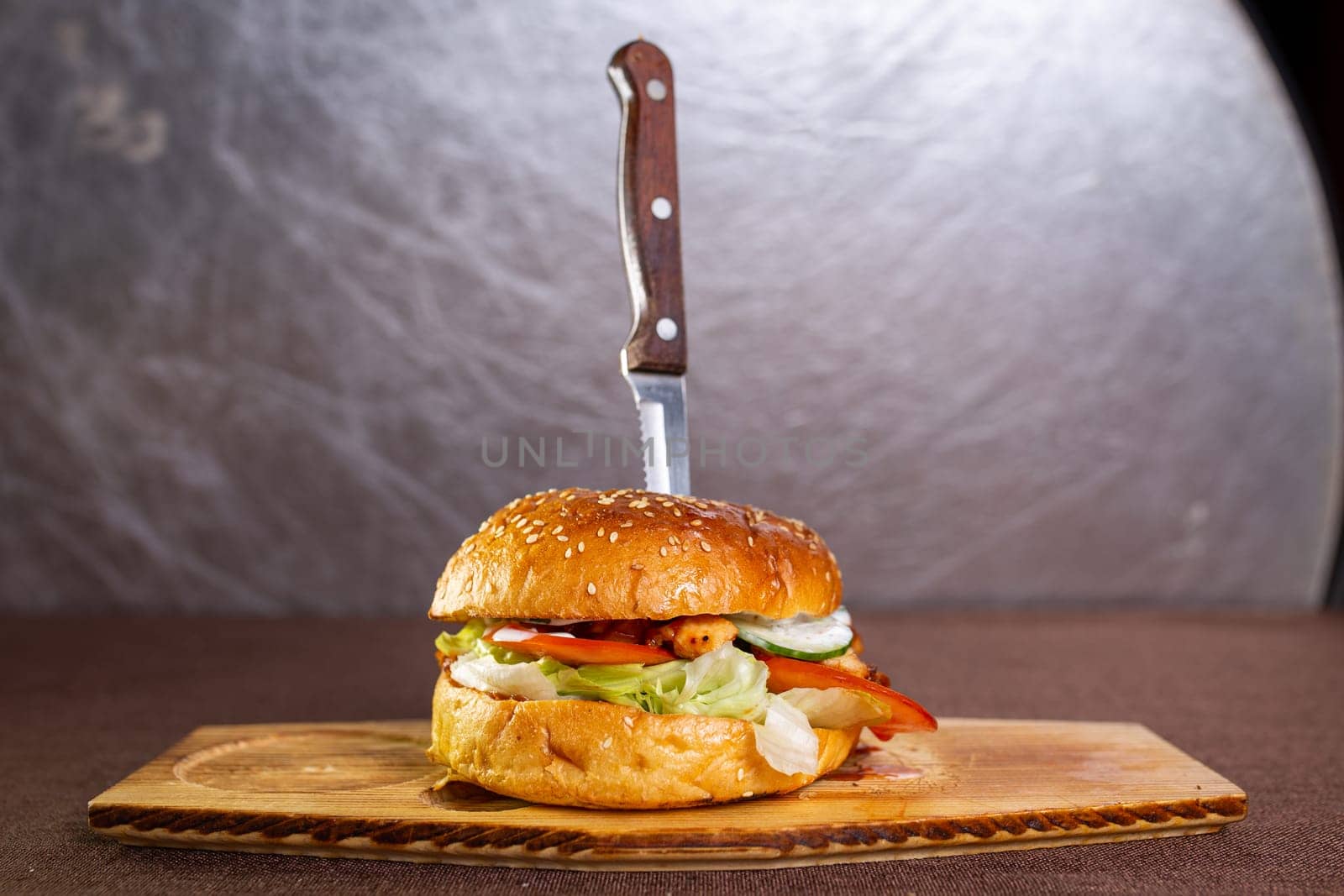 knife stuck in a juicy burger with meatballs by Pukhovskiy