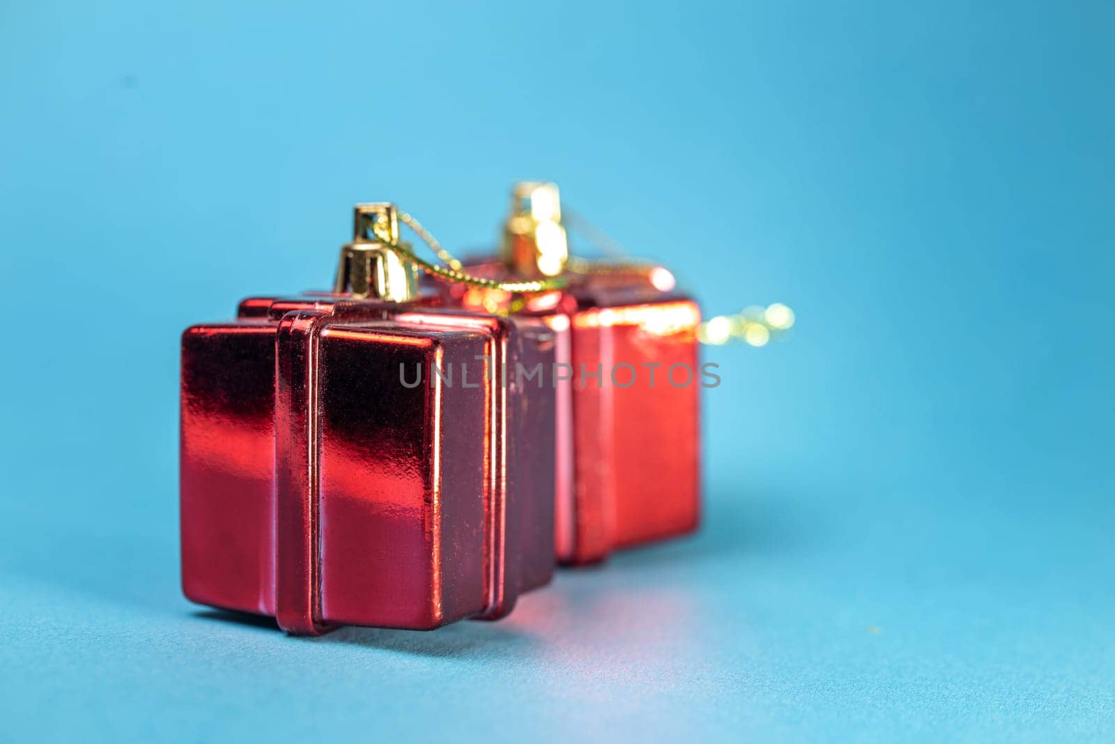 Christmas tree toy in the form of a red gift on a blue background by Pukhovskiy
