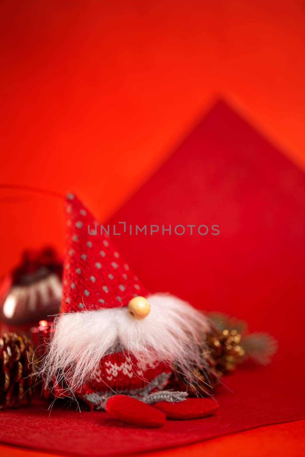 Christmas toy red dwarf or elf on a red background by Pukhovskiy