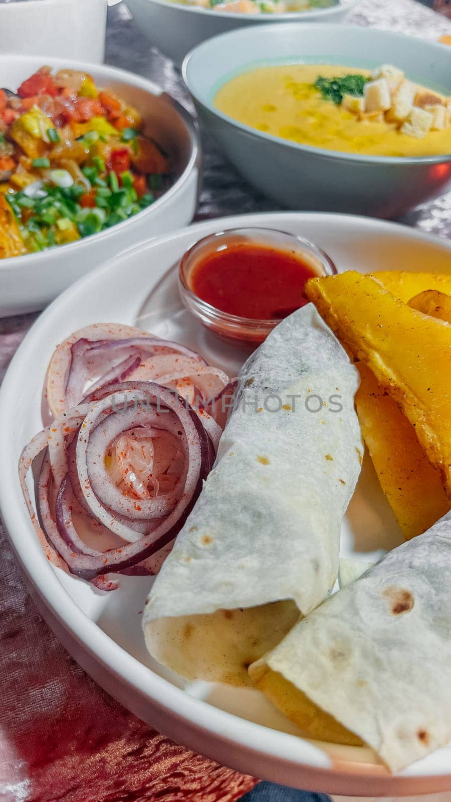 Beef and lamb doner kebab wraps with flatbread and vegetables on a white plate by Pukhovskiy