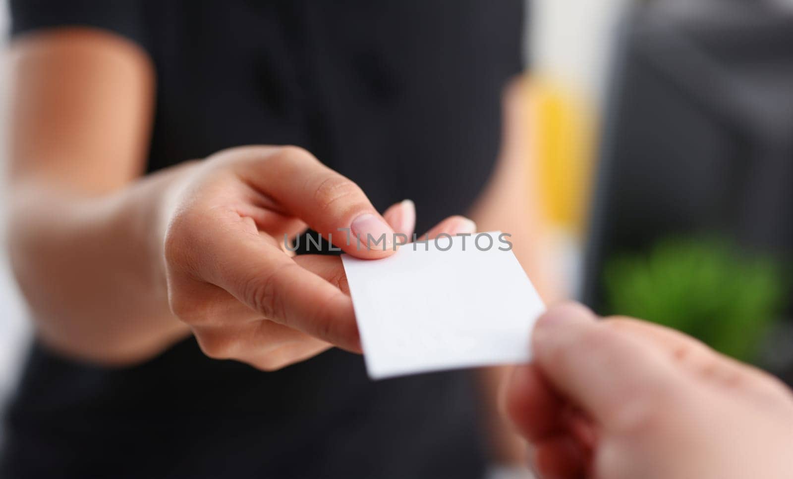 businesswoman give her business card to her new partner closeup by kuprevich