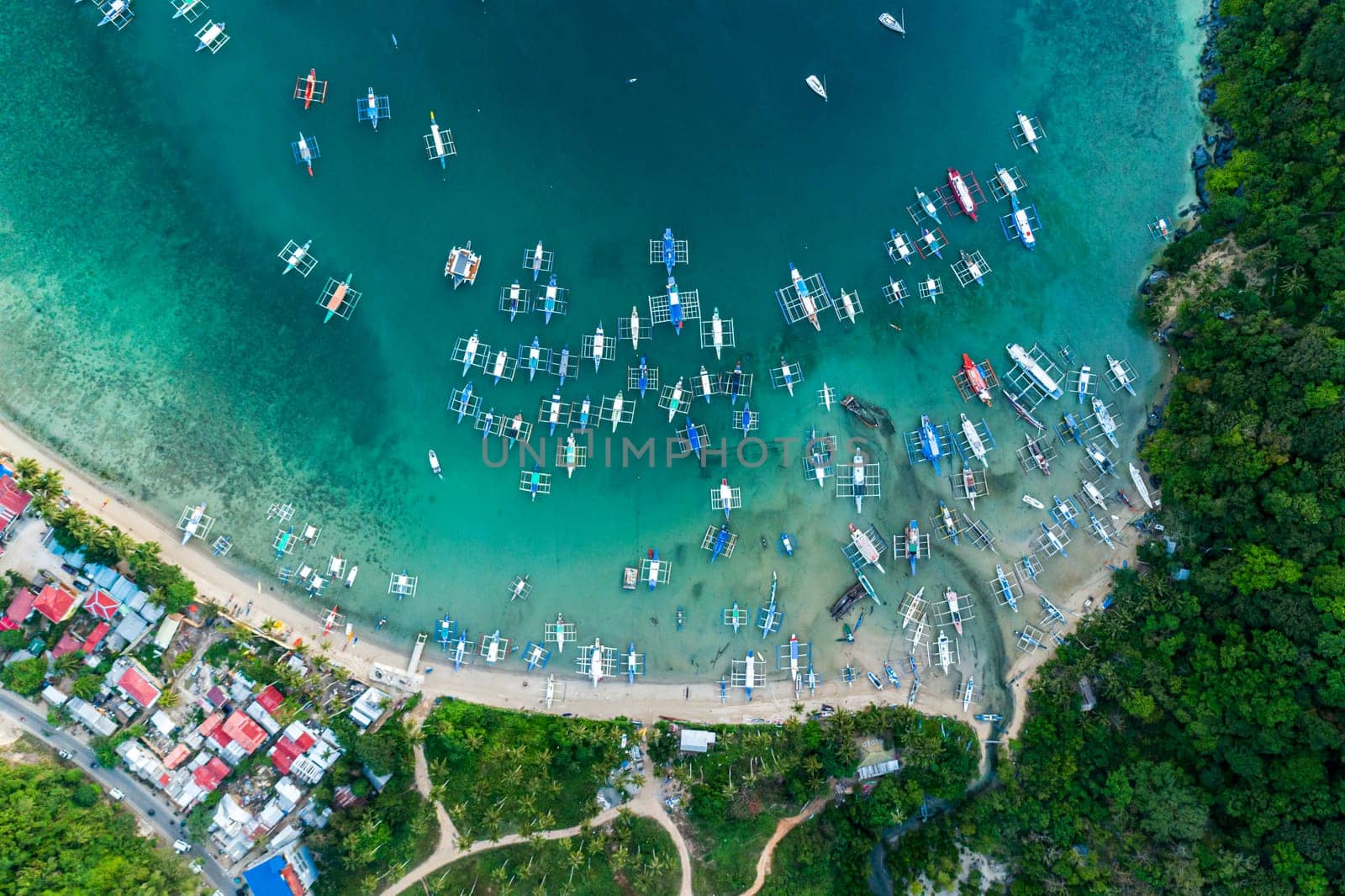 Top drone view of a traditional philippine boats on the surface of the azure water in the lagoon. Seascape with blue bay and boats view from above. El Nido, Palawan, Philippines. by Busker