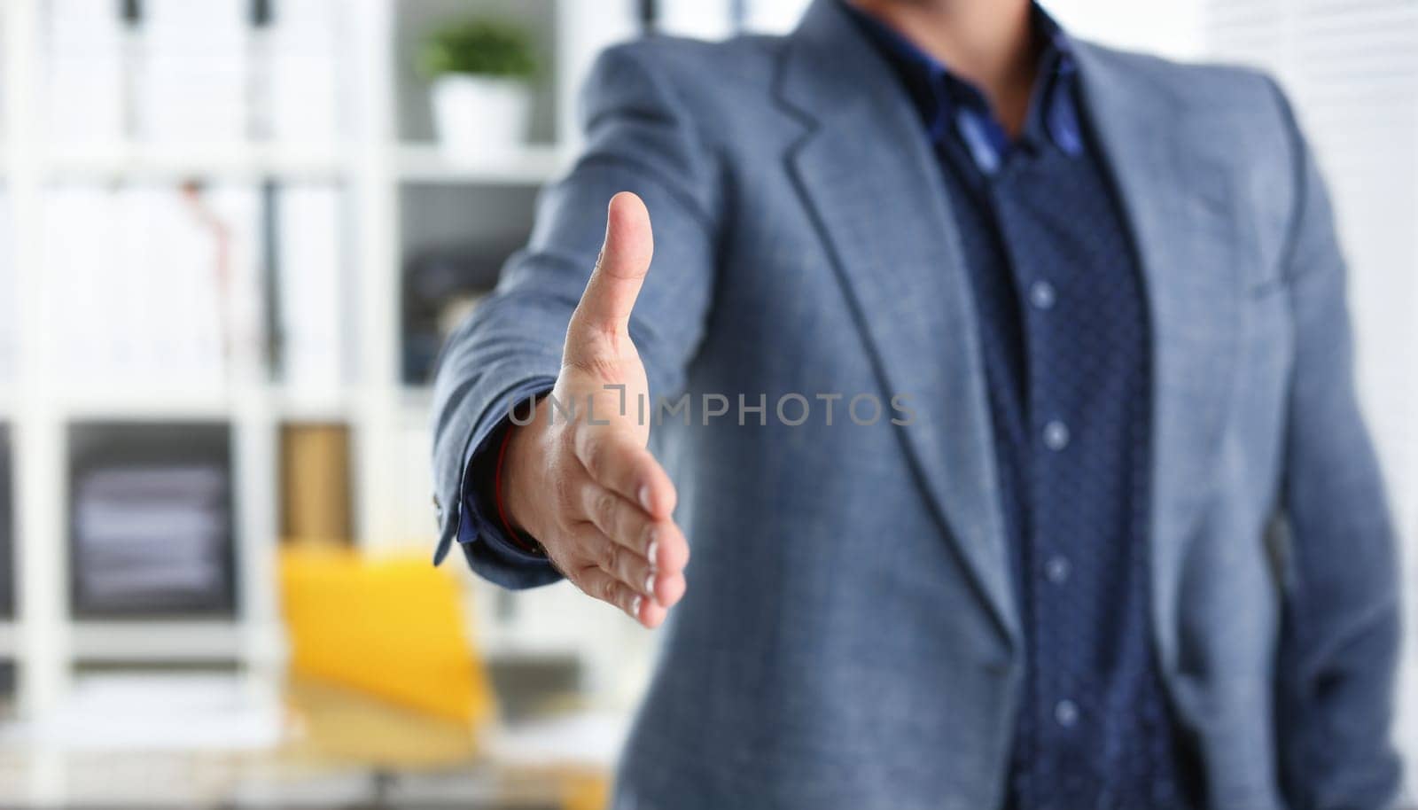 young handsome promising businessman work in office lend hand ahead closeup
