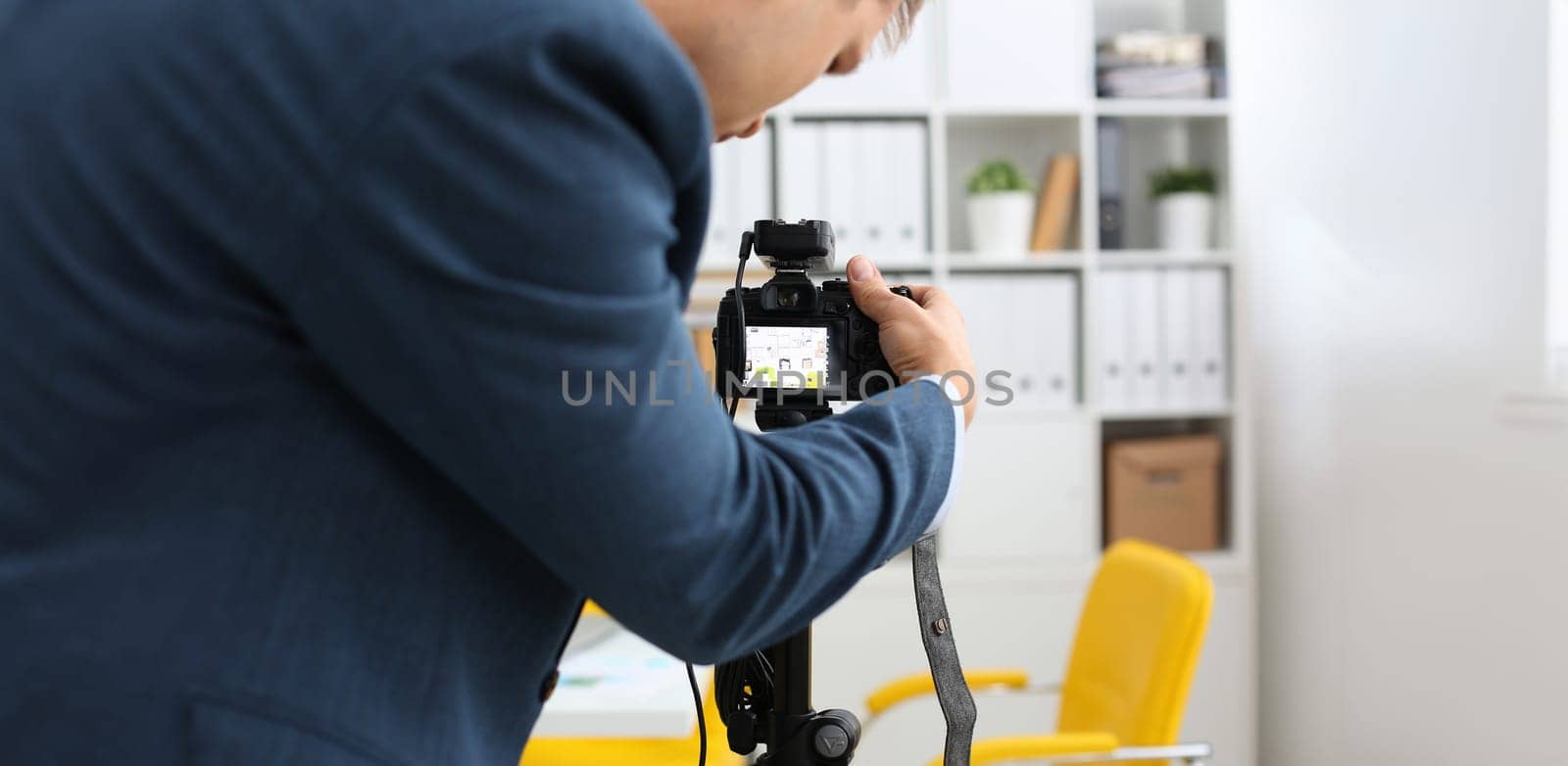 Male arms in suit mount camcorder to tripod by kuprevich