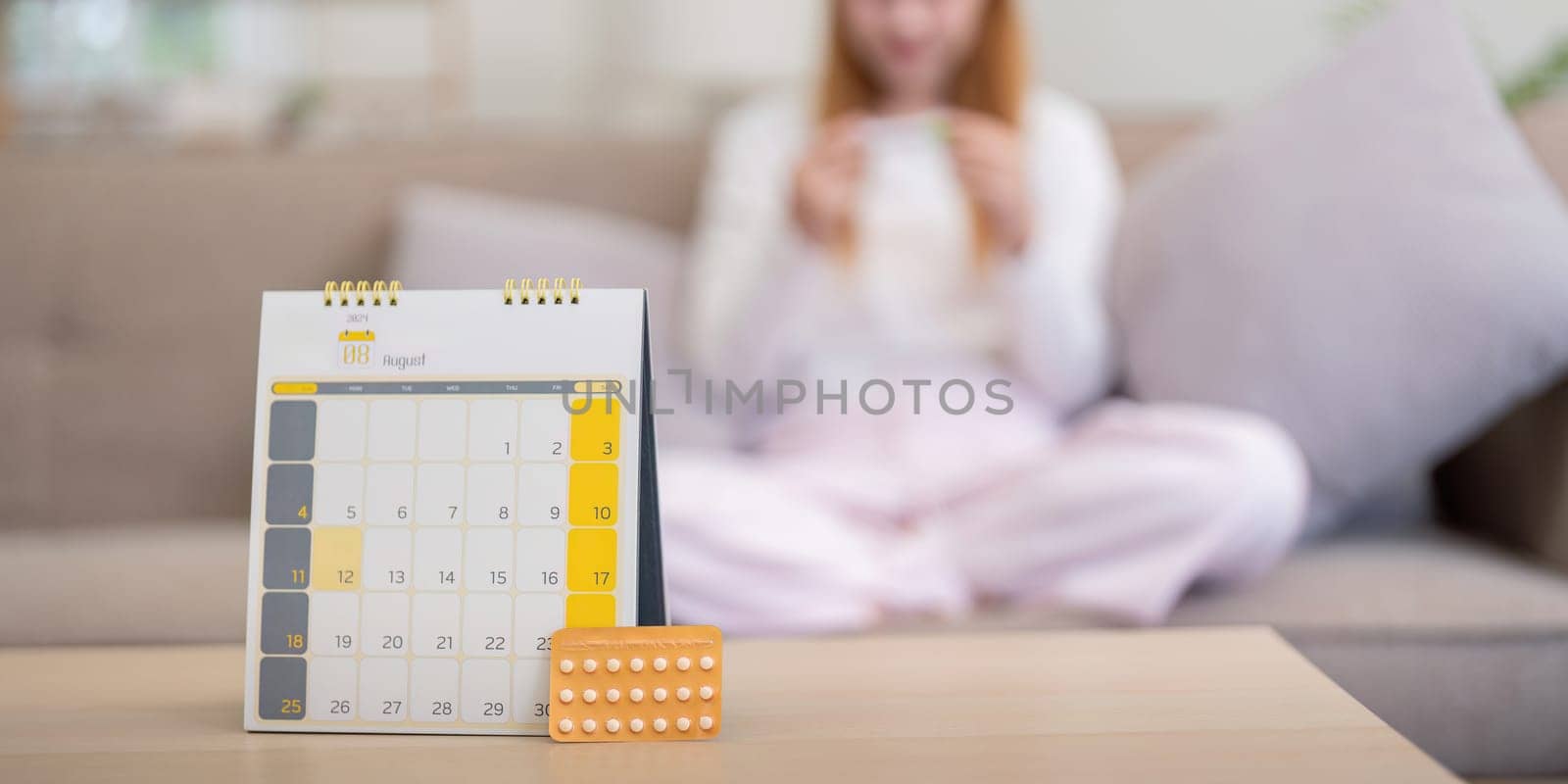 Birth control pills with calendar on table at home. Concept of contraception, family planning, and women's healthcare by nateemee