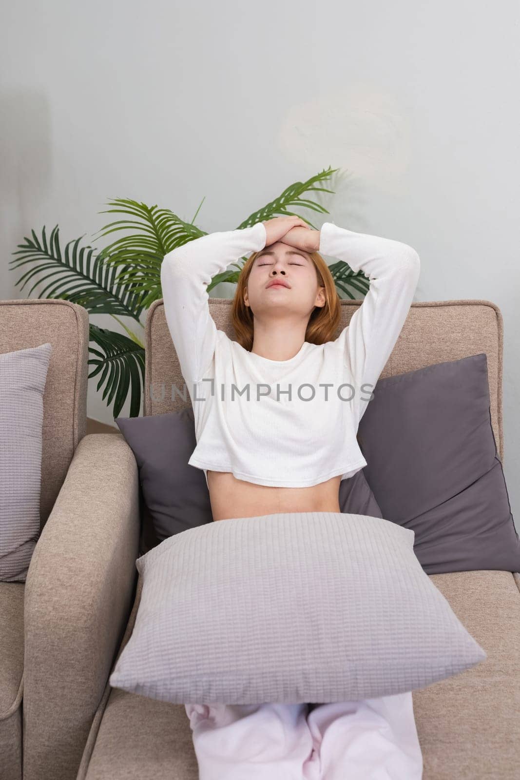 Young Asian woman has headaches from illness or accumulated stress due to health problems and lifestyle problems that cause stress disorder. by wichayada