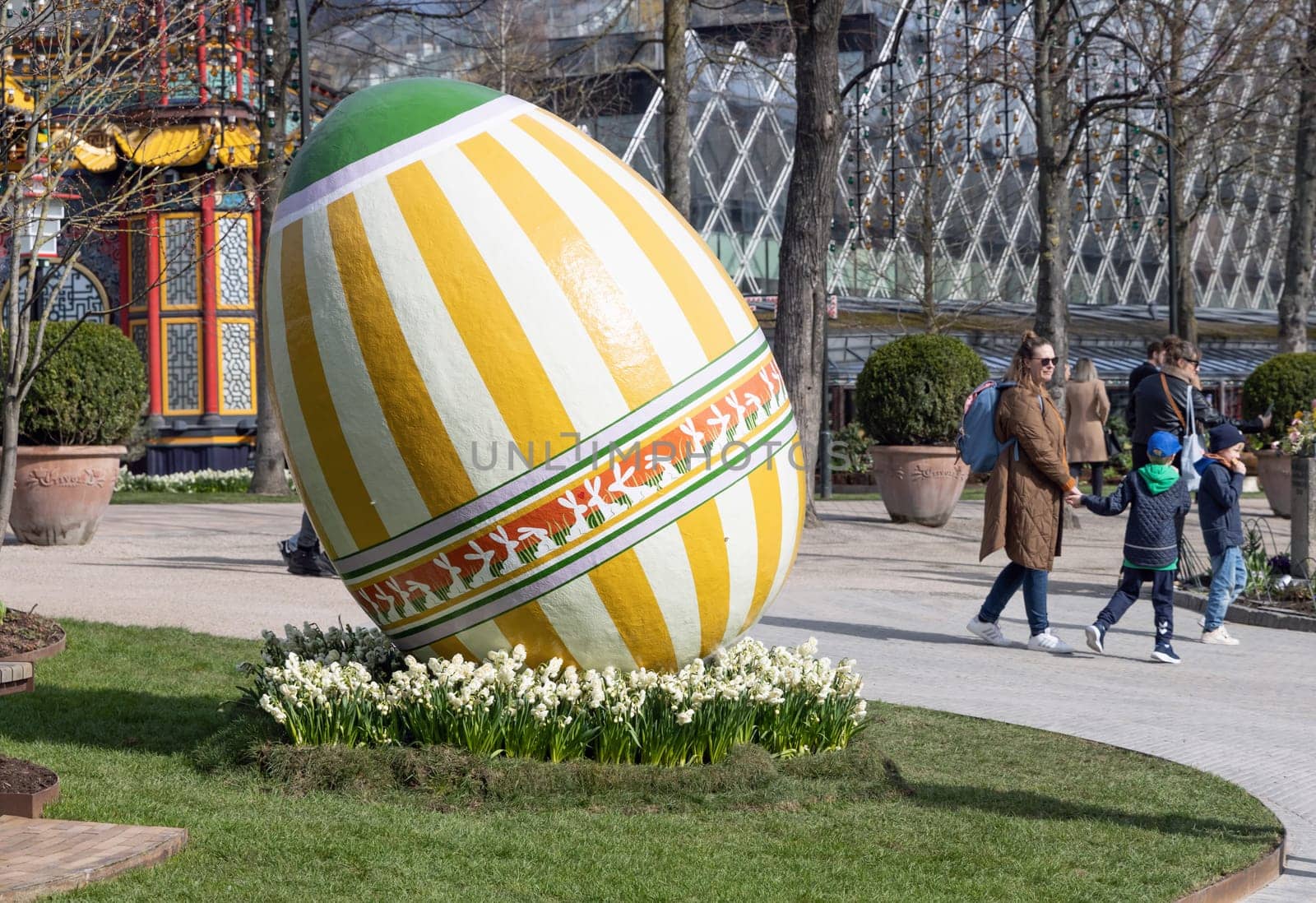 Large decorotive Easter egg on the grass in the park. Easter concept. Copenhagen, Denmark - March 28, 2024