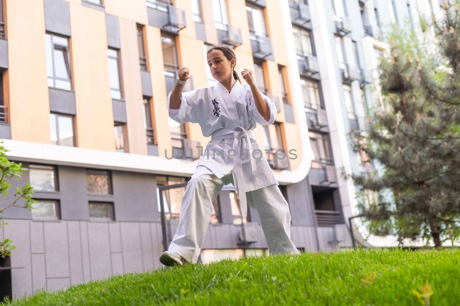 Karate, teenager girl in kimono training by Andelov13