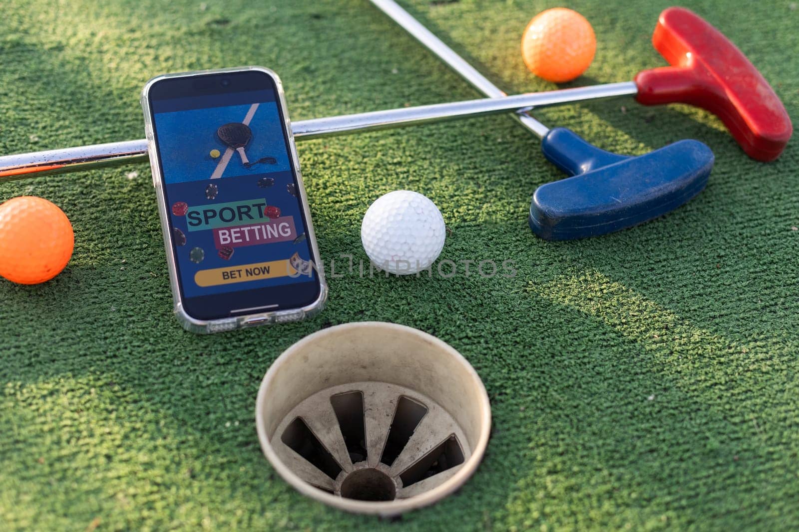golf equipment on the green lawn. mini golf sports betting on a smartphone. High quality photo