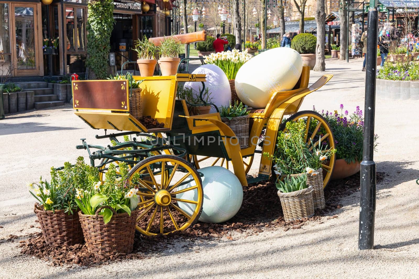 Easter decoration of a carriage with large decorative Easter eggs in a city park. Copenhagen, Denmark - March 28, 2024