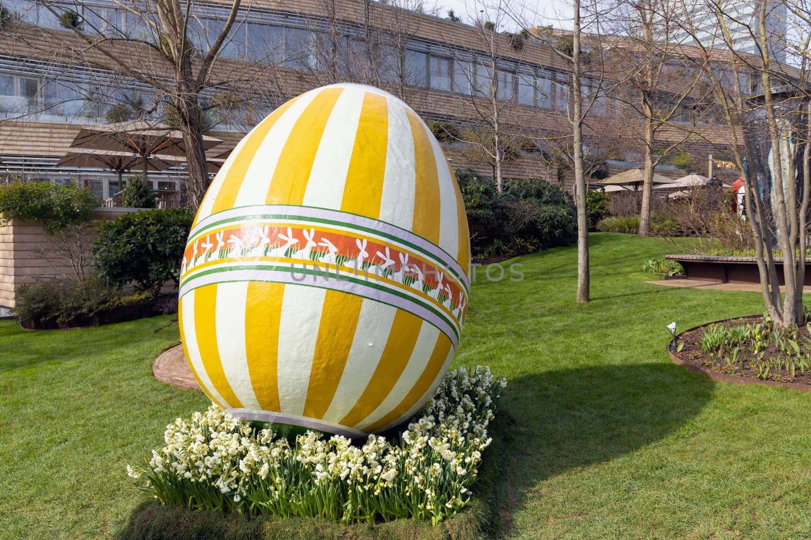 Large decorotive Easter egg on the grass in the park. Easter concept.