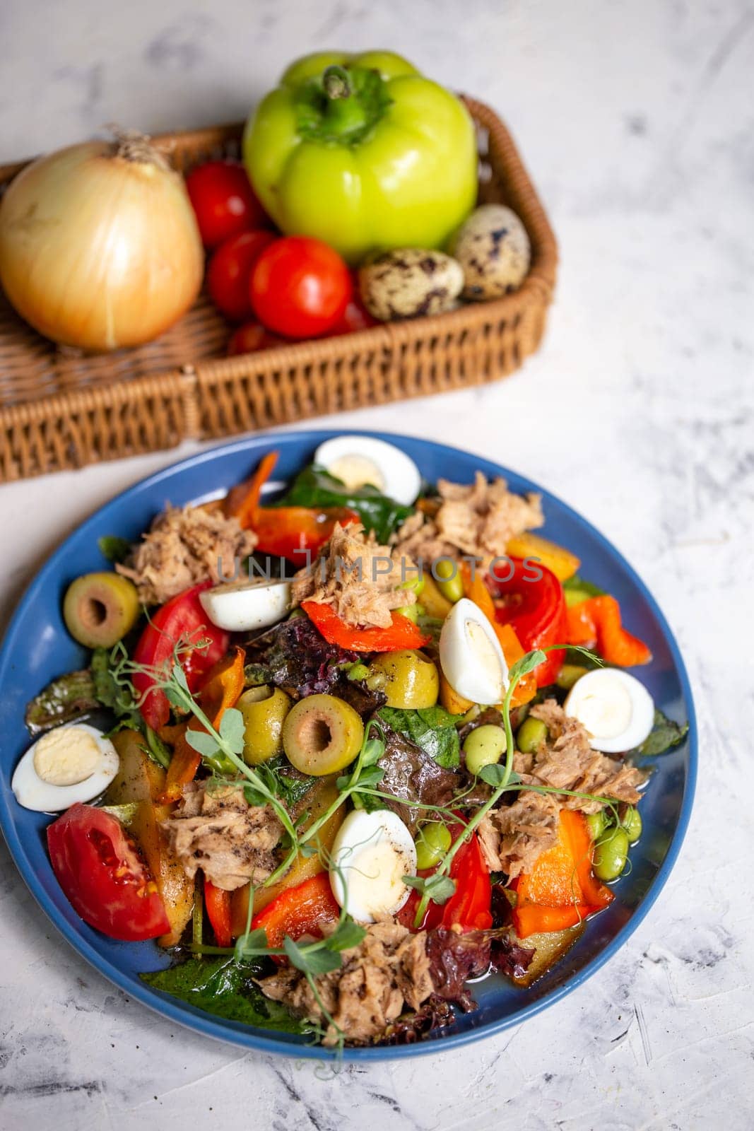 nicoise salad with tuna on the table with vegetables top view.