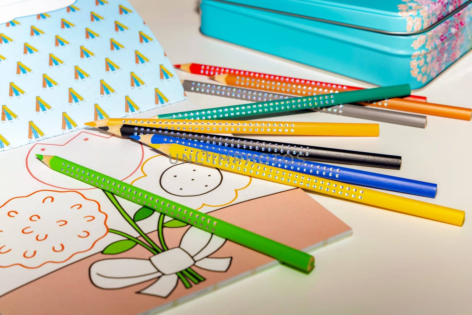 Colored pencils for drawing various colors andcoloring book for children. High quality photo