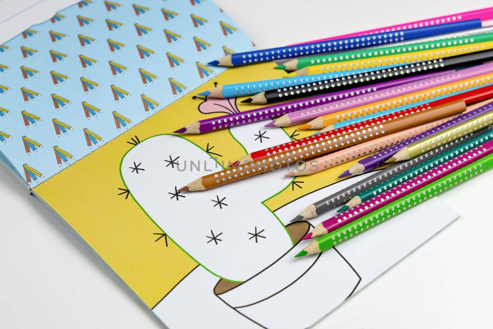 Colored pencils for drawing various colors andcoloring book for children. High quality photo