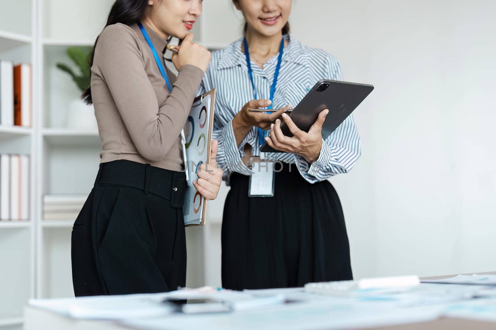 businesspeople woman professionals working in office, Colleagues using digital tablet in coworking, coworkers working together in boardroom, brainstorming, discussing and analyzing business strategy.