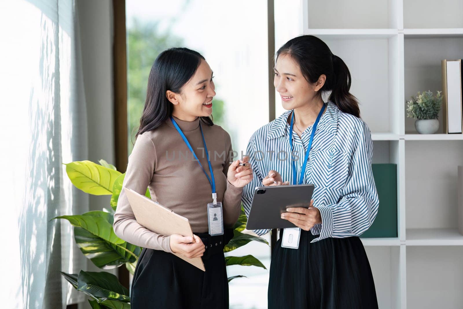 businesspeople woman professionals working in office, Colleagues using digital tablet in coworking, coworkers working together in boardroom, brainstorming, discussing and analyzing business strategy.