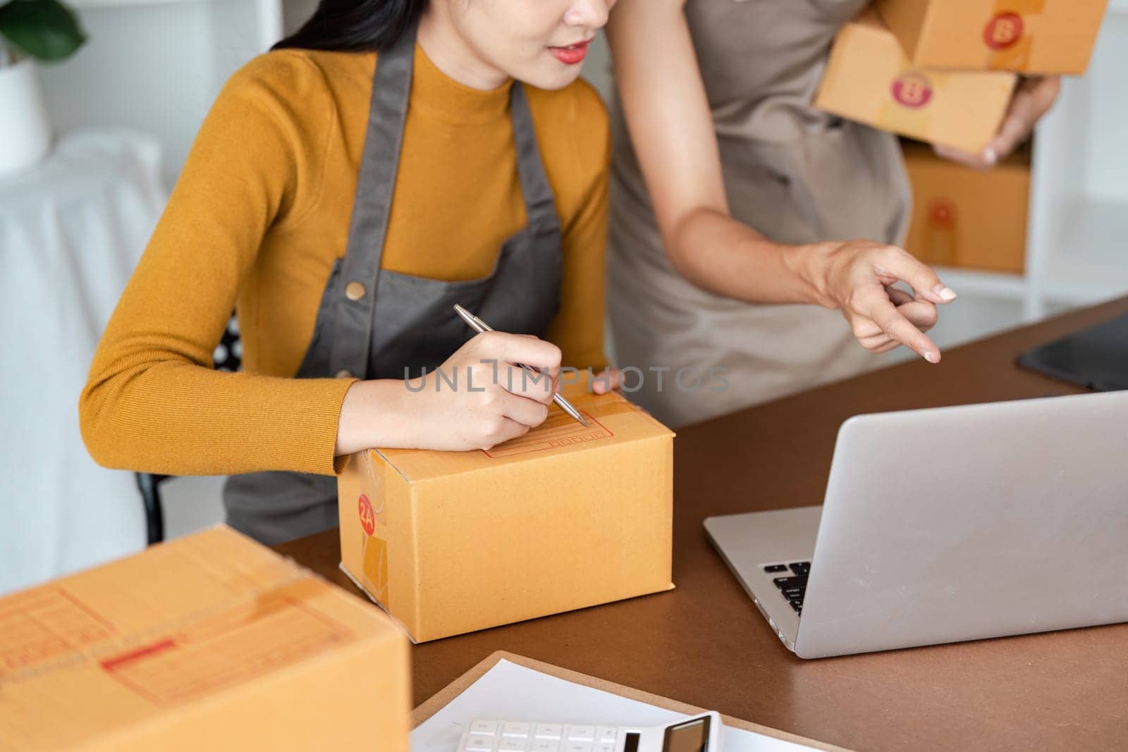 Young business entrepreneur using laptop. Preparing for shipping, online selling, e-commerce concept.