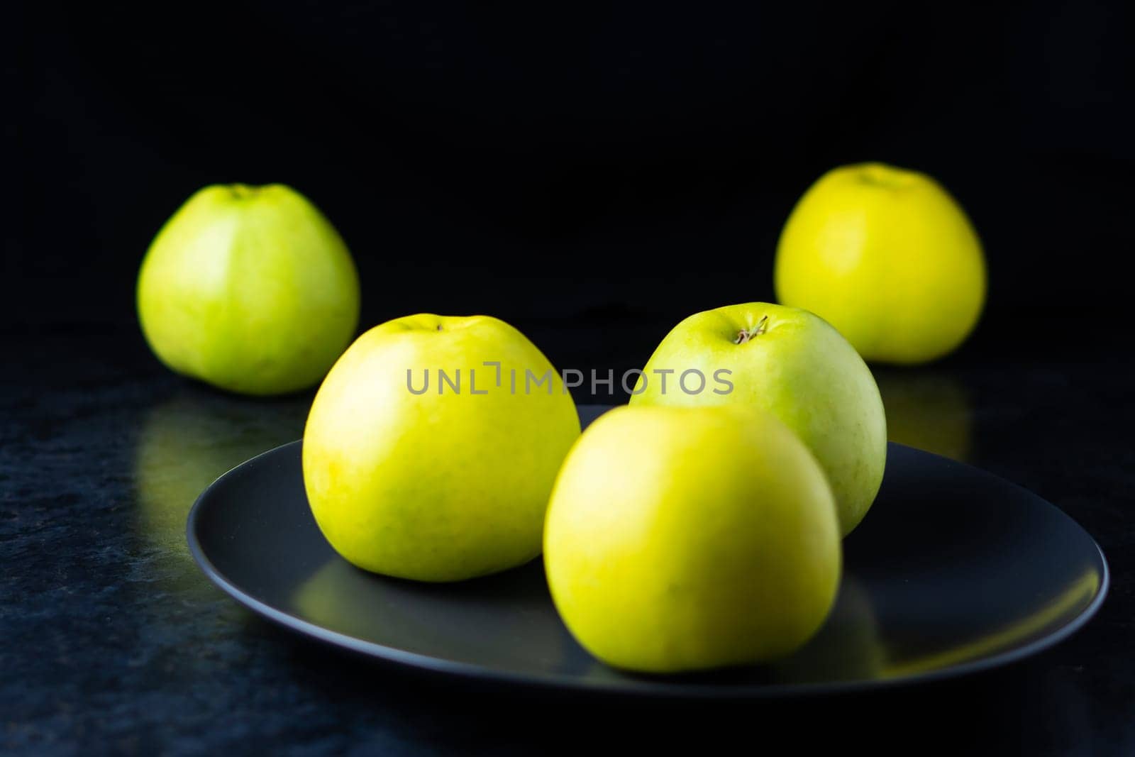 Fresh ripe green apples on wooden table against dark background, space for text by Zelenin