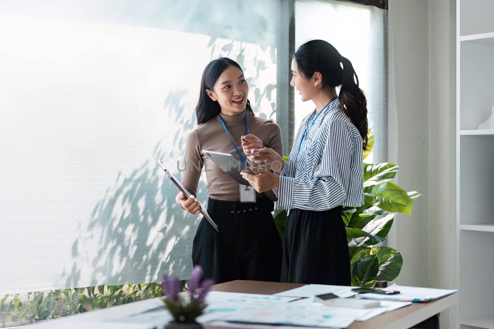 businesspeople woman professionals working in office, Colleagues using digital tablet in coworking, coworkers working together in boardroom, brainstorming, discussing and analyzing business strategy.