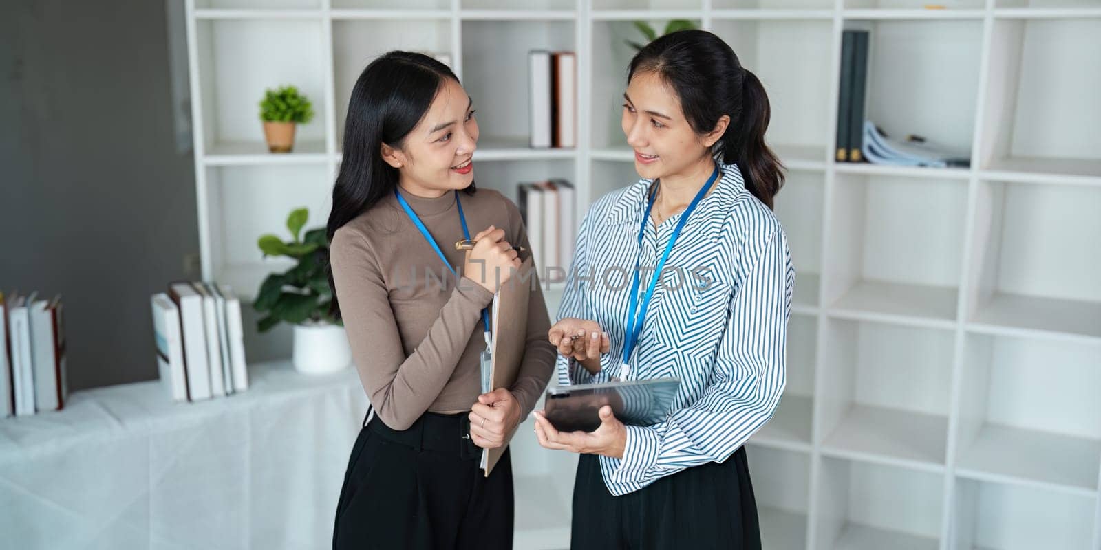 businesspeople woman professionals working in office, Colleagues using digital tablet in coworking, coworkers working together in boardroom, brainstorming, discussing and analyzing business strategy by itchaznong