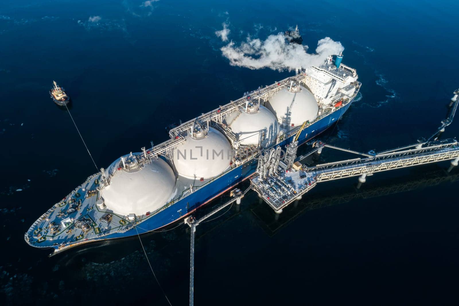 Large lng tanker docked at industrial port terminal for cargo operations