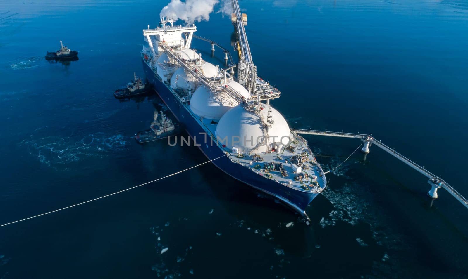 Large lng tanker docked at industrial port terminal for cargo operations by Busker