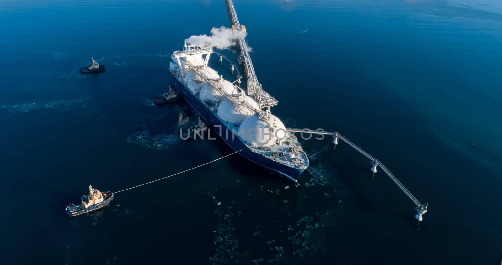 Large lng tanker docked at industrial port terminal for cargo operations by Busker