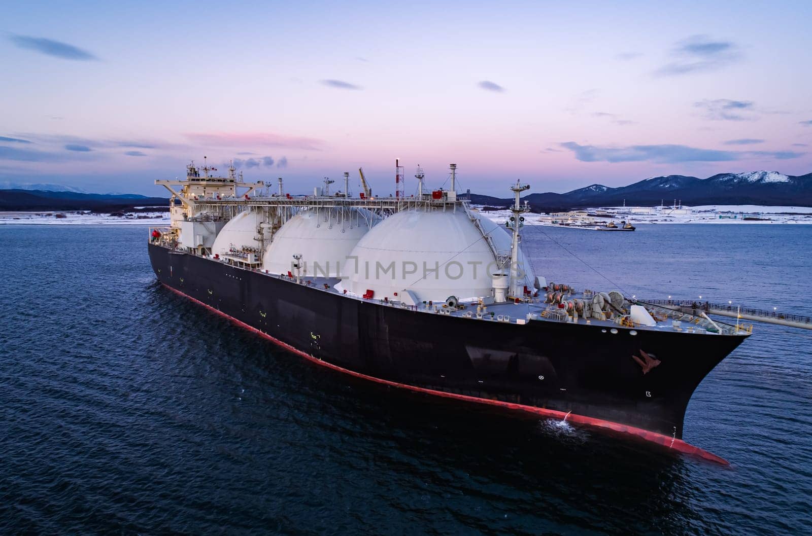 Aerial of Liquified Natural Gas LNG carrier moored to a small gas terminal. Fuel crisis. Sanctions.