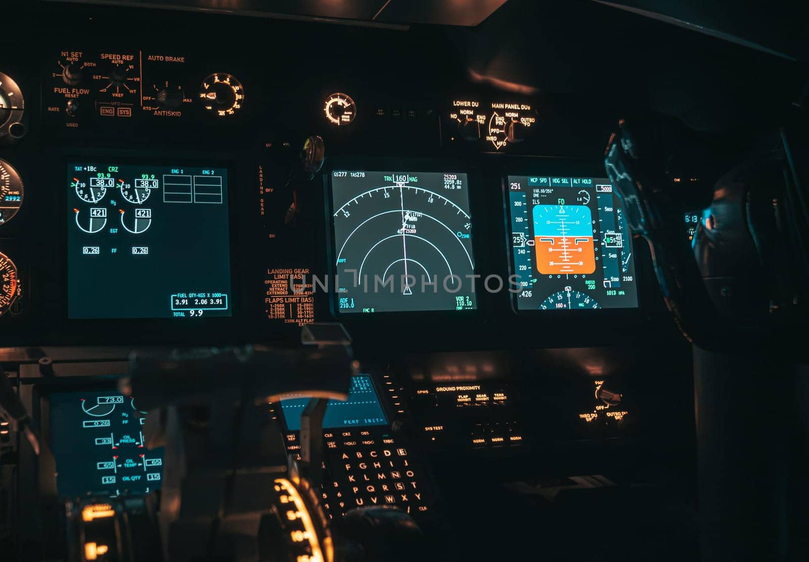 Cockpit view of an airplane during a night-time flight with illuminated instrument panels