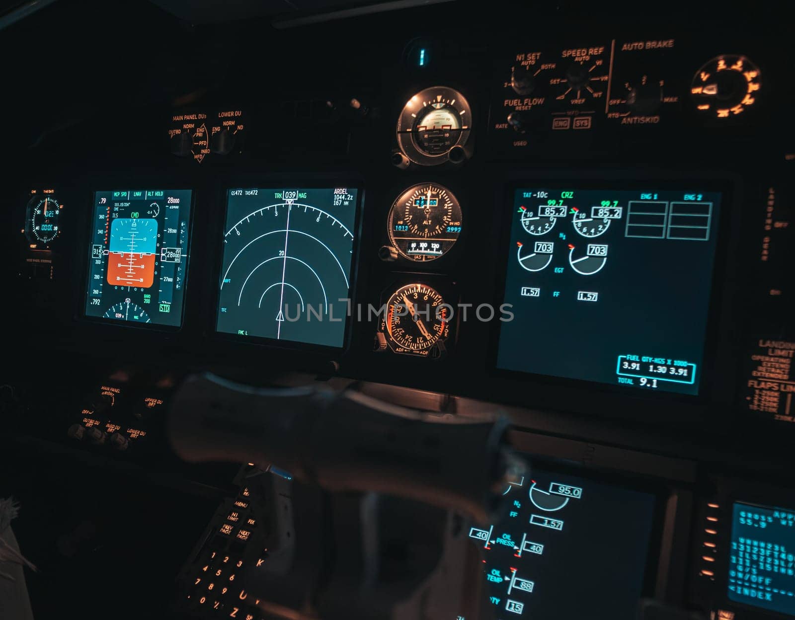 Cockpit view of an airplane during a night-time flight with illuminated instrument panels