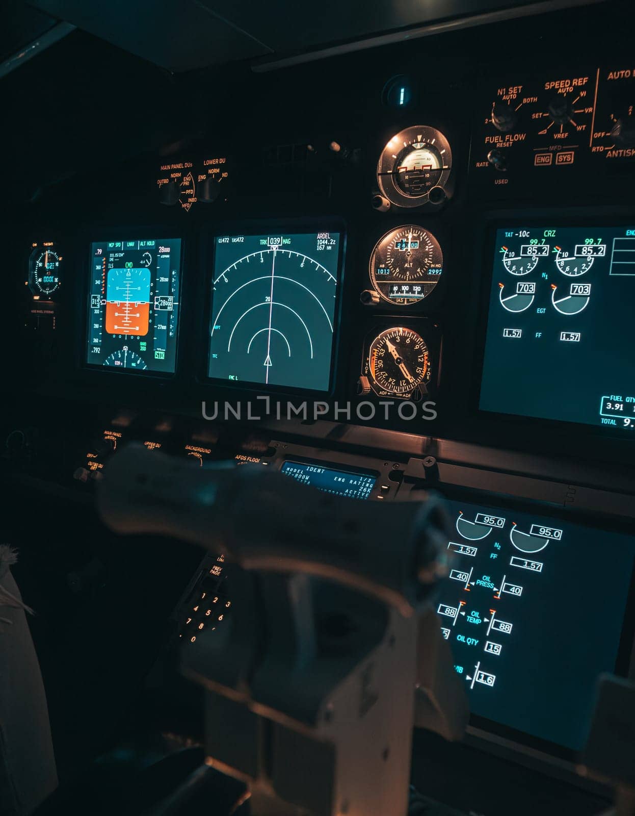 Cockpit view of an airplane during a night-time flight with illuminated instrument panels