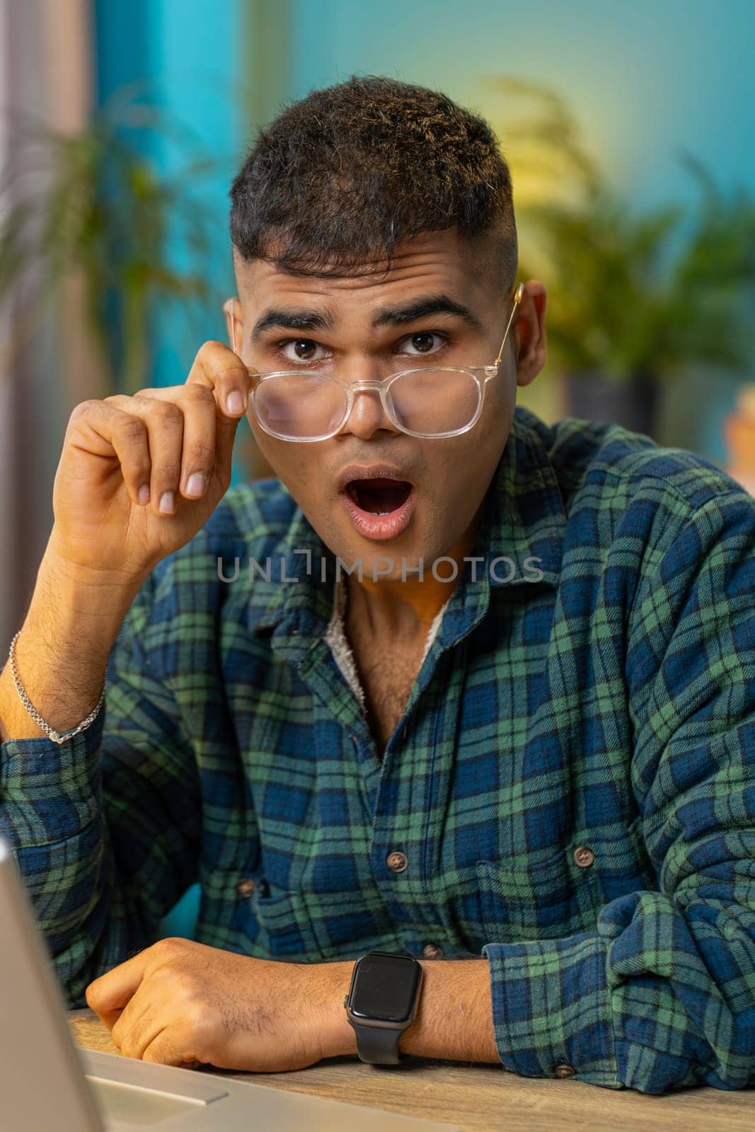 Oh my God, Wow. Excited amazed Indian man taking off glasses surprised looking at camera with big eyes shocked by sudden victory good win news celebrating success triumph sitting at home. Vertical