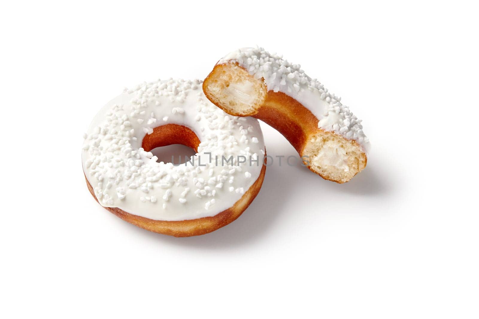 Two sweet soft donuts with creamy filling, white vanilla icing and sugar sprinkles presented on seamless white background. Popular confectioneries