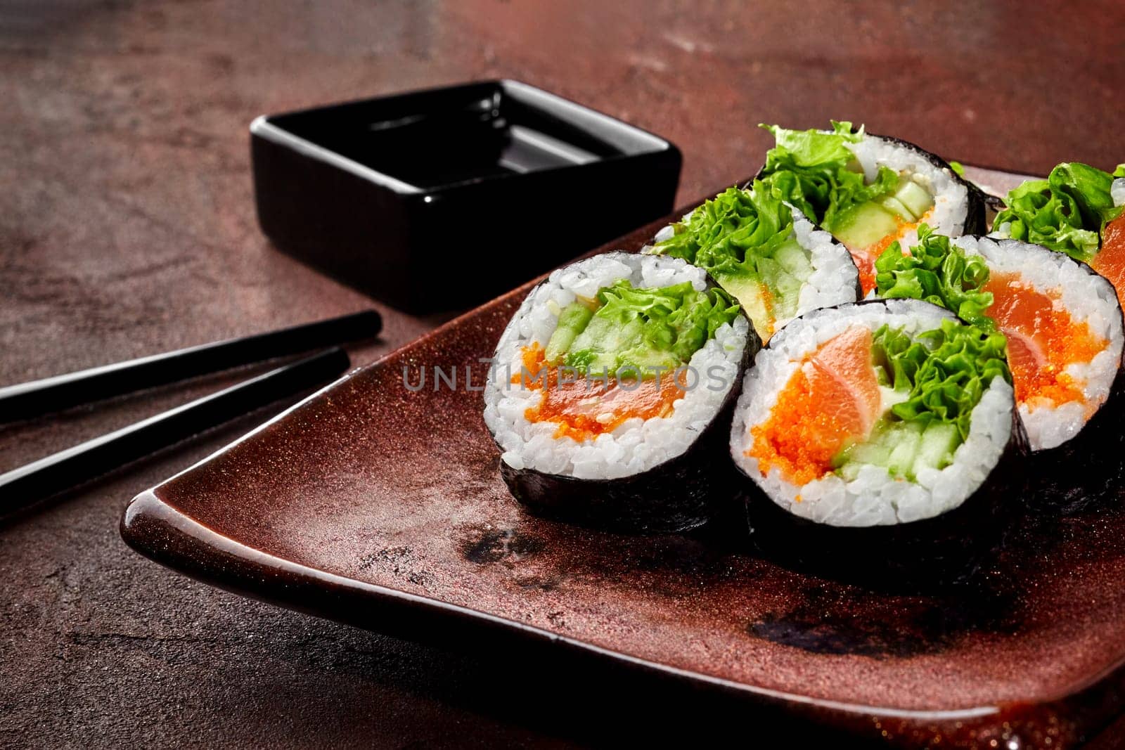 Colorful salmon and cucumber maki sushi rolls with soy sauce by nazarovsergey