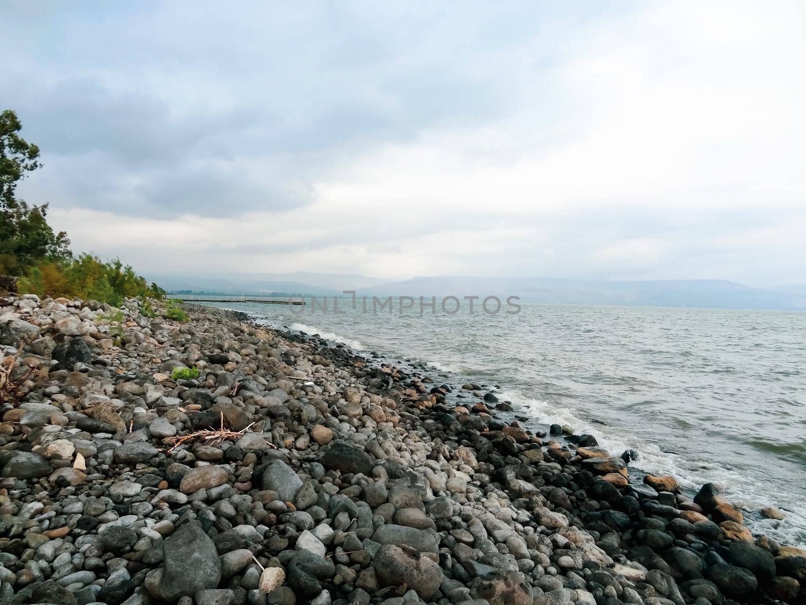 Rocky shore of the sea or lake.The sea of Galilee also called Lake Tiberias or Kinneret, Israel. High quality photo