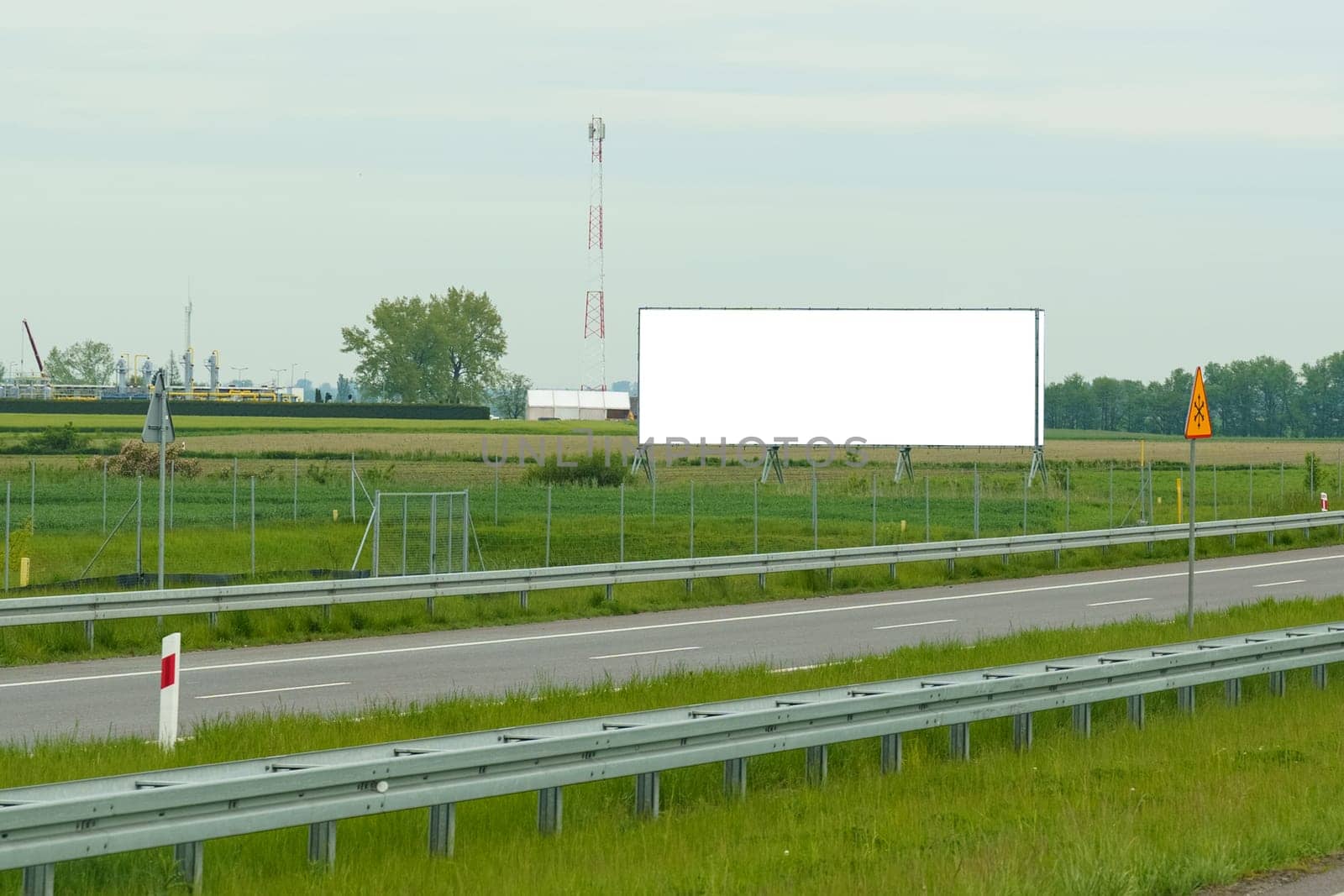 Large billboard promoting a product or service on the side of a bustling highway, attracting the attention of passing motorists.