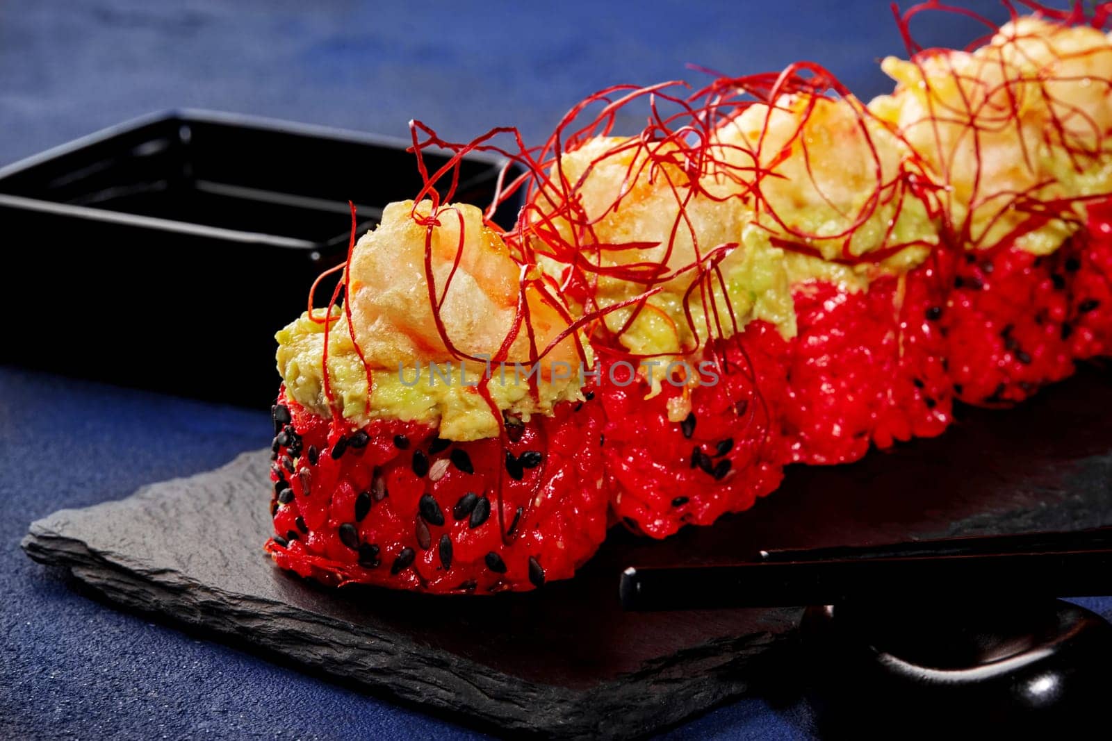Red sushi rolls with avocado, shrimp and togarashi threads by nazarovsergey
