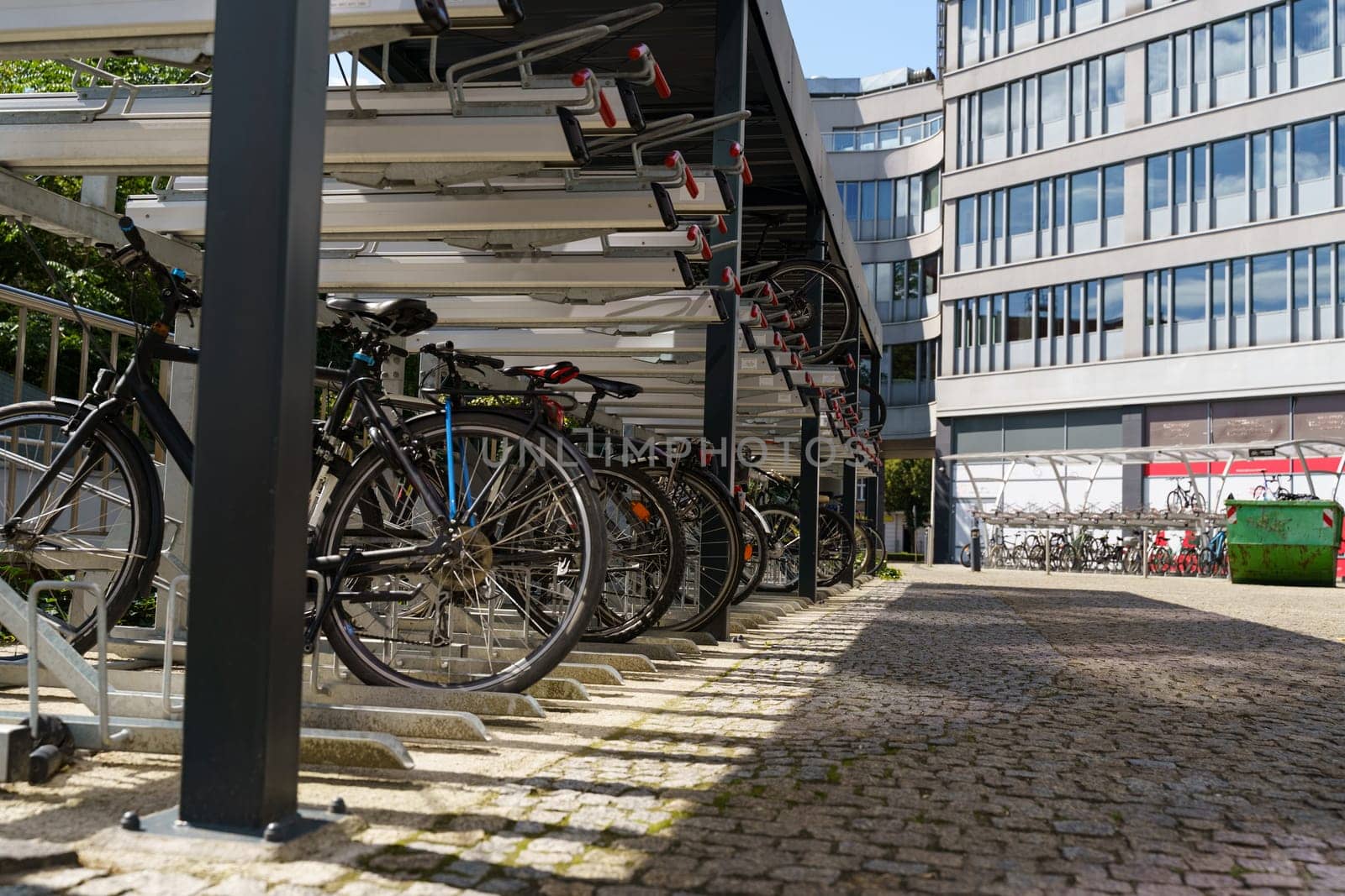 Multiple bicycles neatly parked in rows in front of a building, with various colors and designs visible.