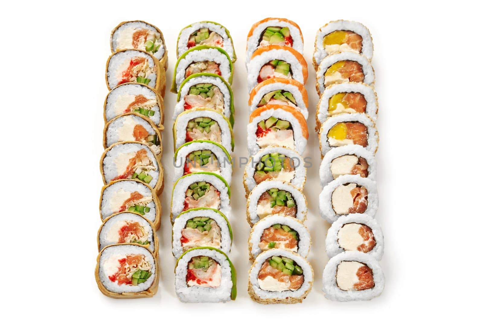 Enticing set of various sushi rolls with salmon, tobiko, cream cheese, mango and vegetables arranged on white background. Popular Japanese snacks concept