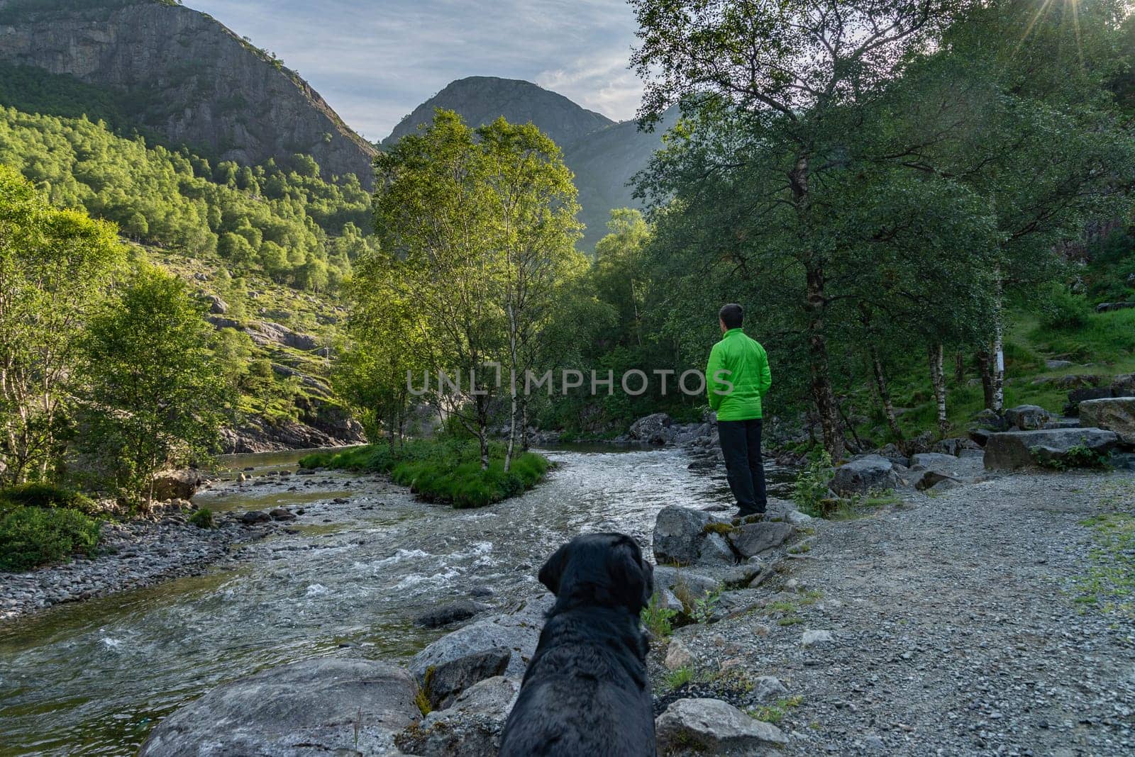 Man and Dog Enjoying Mountain River Scenery by JavierdelCanto